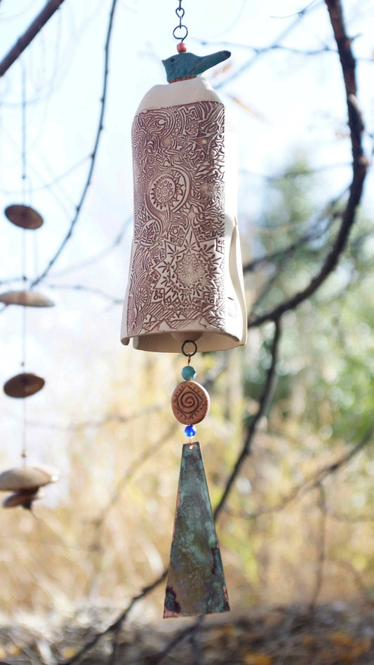White ceramic wind chime with blue glazed bird topper and patinaed copper sail