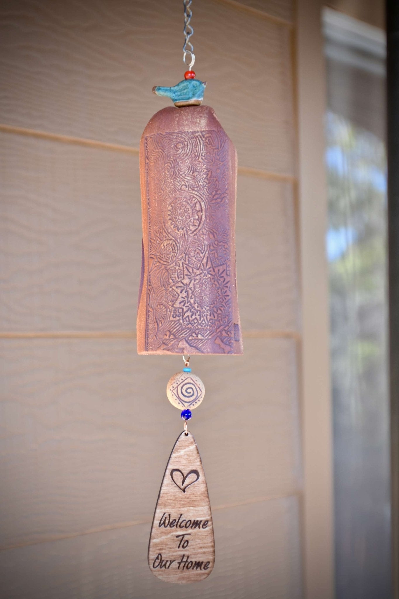 Mixed clay ceramic wind chime with blue glazed bird and engraved wooden wind sail