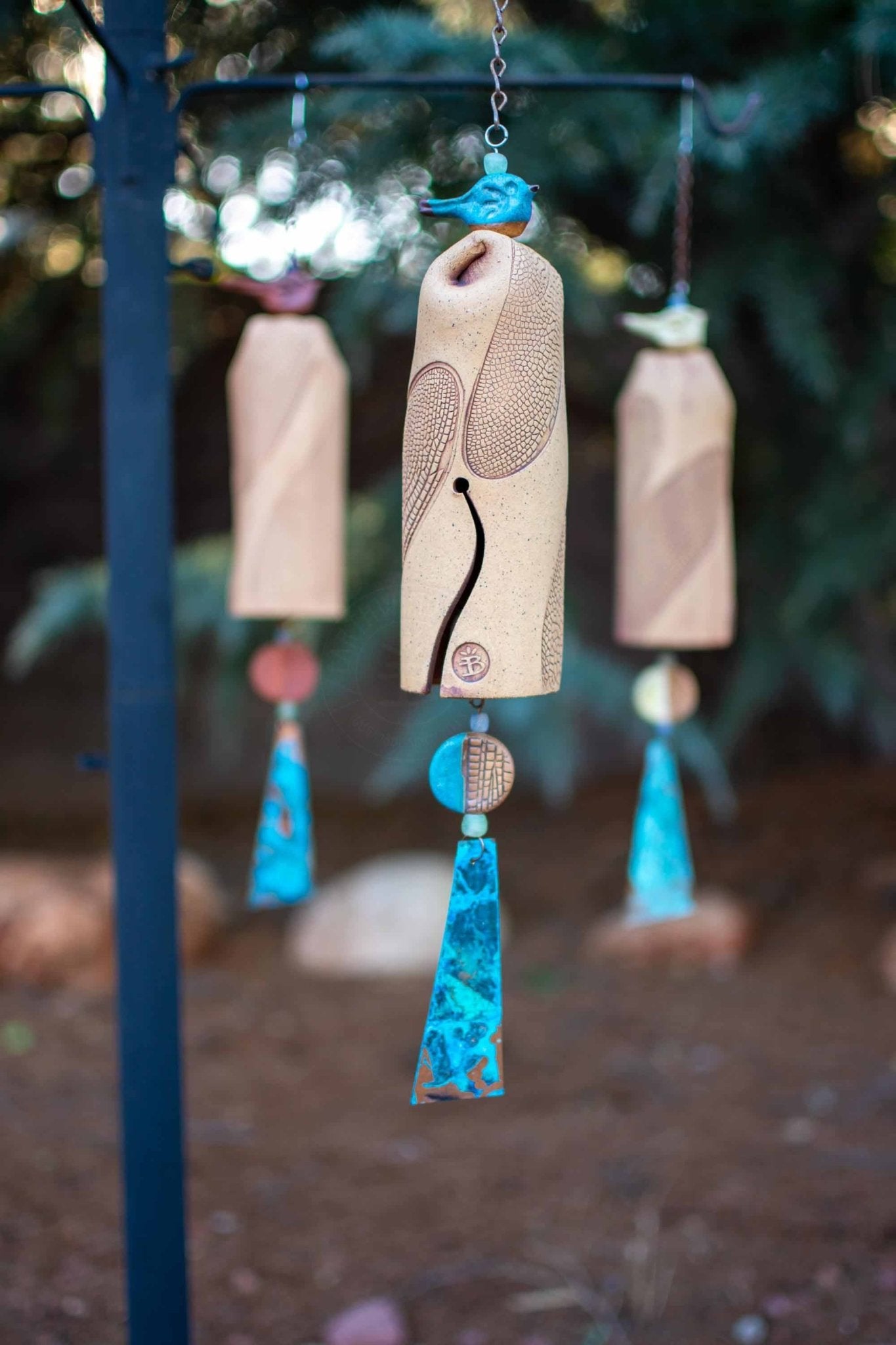 Artisan-crafted ceramic dragonfly wind chime for outdoors, with changing copper patina.