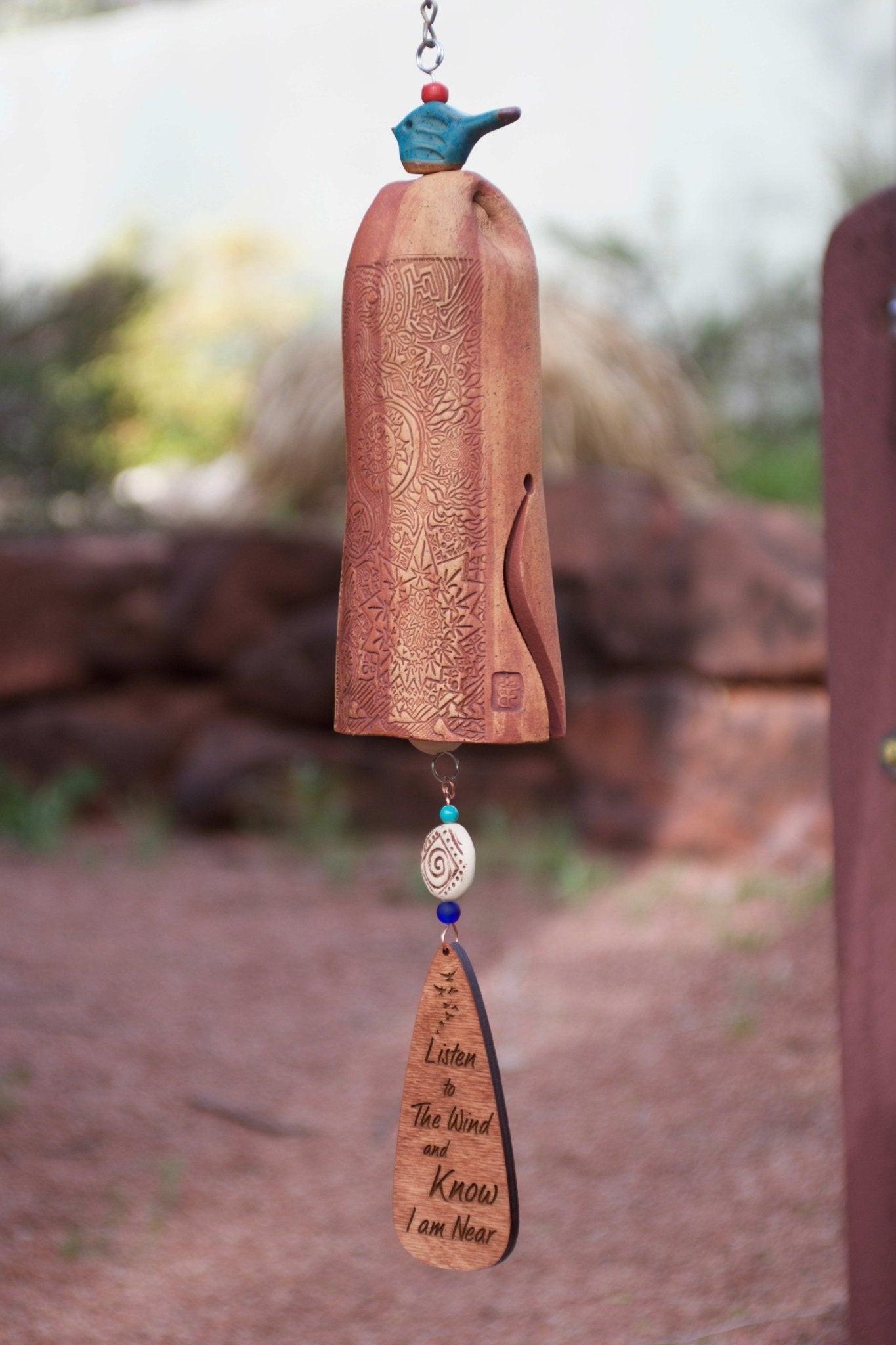 Close-up of “Listen to the Wind and Know I’m Near” etched wind sail on memorial chime